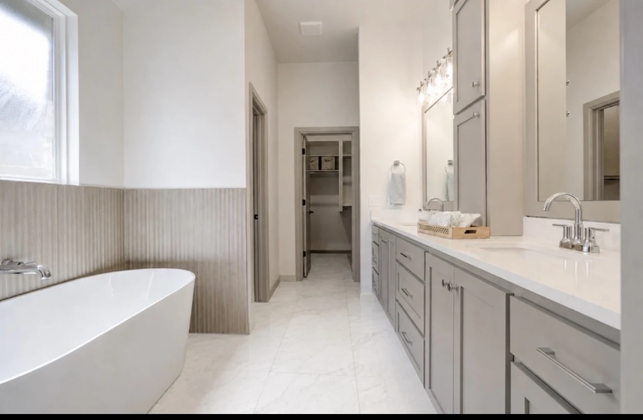 Johnson Project bathroom with freestanding white tub, gray double vanity, vertical textured tile, and marble-look flooring